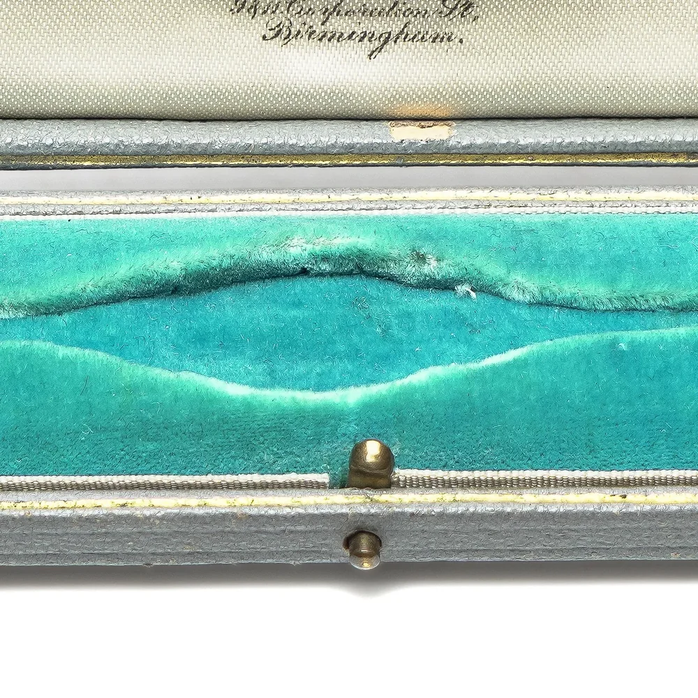 The turquoise velvet bed of an Art Deco watch or bracelet box, raised and curved to hold a bracelet open