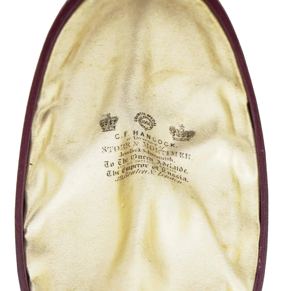 The silk lid of a C.F. Hancock pendant case printed with two crowns, the Council Medal 1851 roundel, Successor of Storr & Mortimer, To the Queen Adelaide and the Emperor of Russia, 39 Bruton St, London