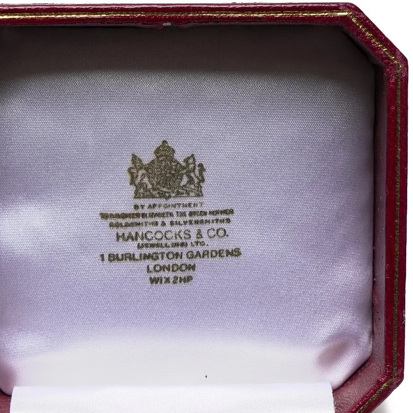 A Hancocks & Co. (Jewellers) Ltd brooch box lid printed with the royal arms, the Queen Mother's warrant, 1 Burlington Gardens, London and a full postcode