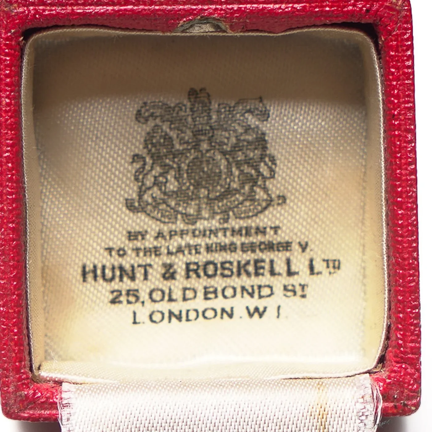 The satin lid of a Hunt & Roskell Ltd ring box printed with the royal arms, By Appointment to the late King George V, Hunt & Roskell Ltd, 25 Old Bond St, London W.1