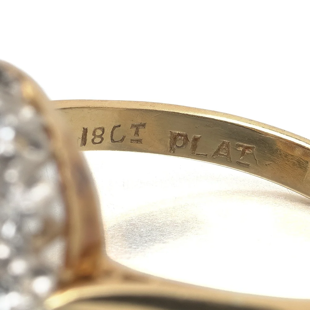 The stamps 18CT and PLAT struck inside the gold shank of an antique topaz and diamond cluster ring