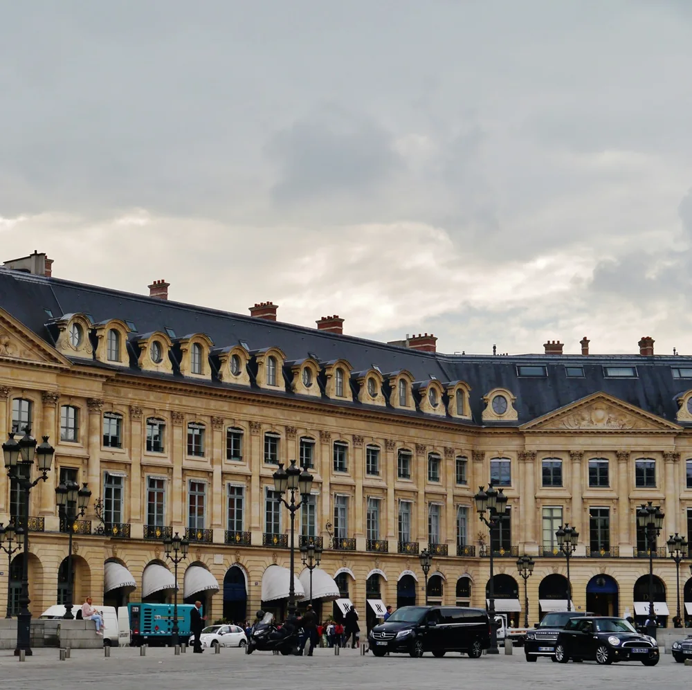 The stone facades, mansard roofs and arcades of the Place Vendome in Paris under a grey sky