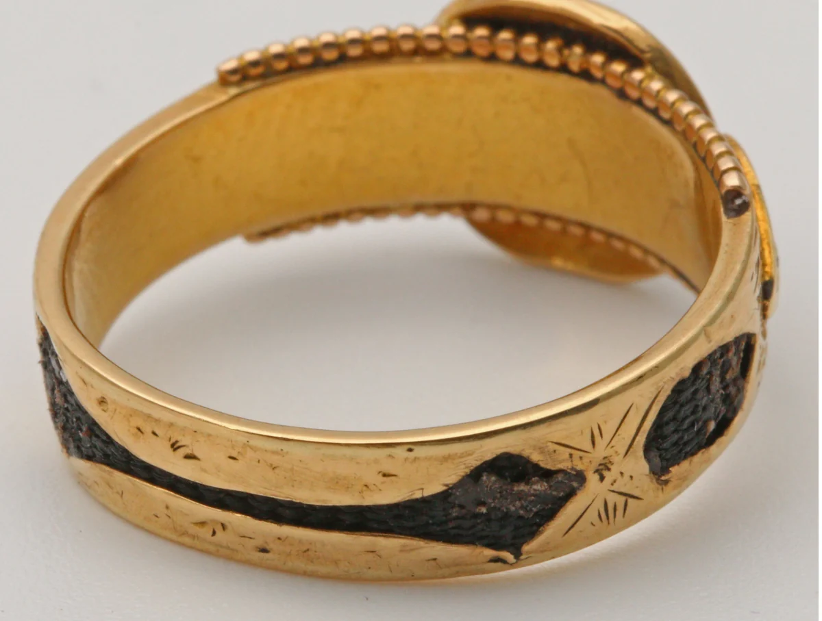 The band of a Victorian 18ct gold mourning ring hallmarked Chester 1891, with dark hair set into panels in the gold beneath a beaded edge