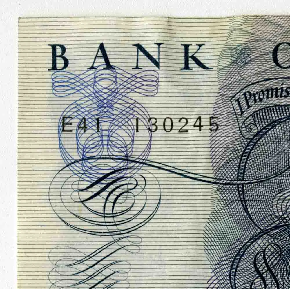 Detail of the top left corner of a 1963 Bank of England five pound note, showing the serial number E41 130245 under the words Bank of England