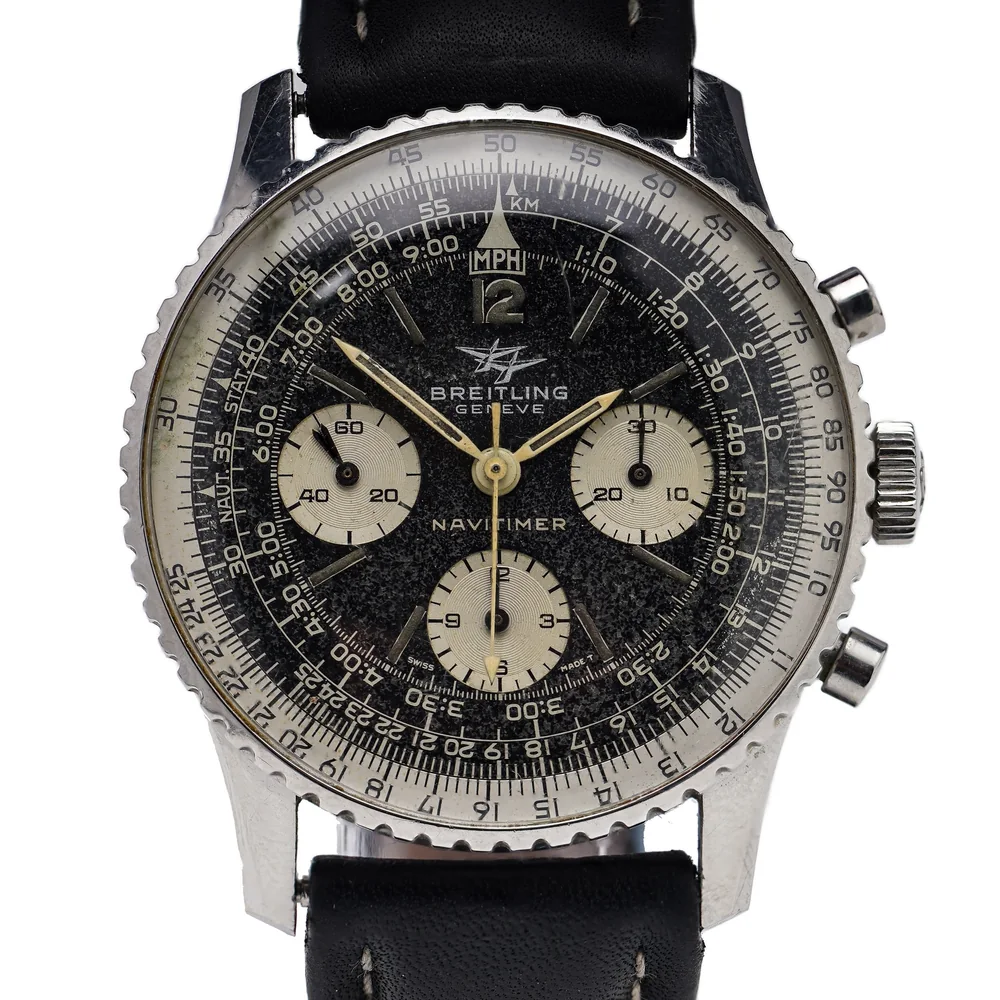 A 1960s Breitling Navitimer 806 with a black dial, three cream sub-dials, the twin-jet logo and a slide rule bezel
