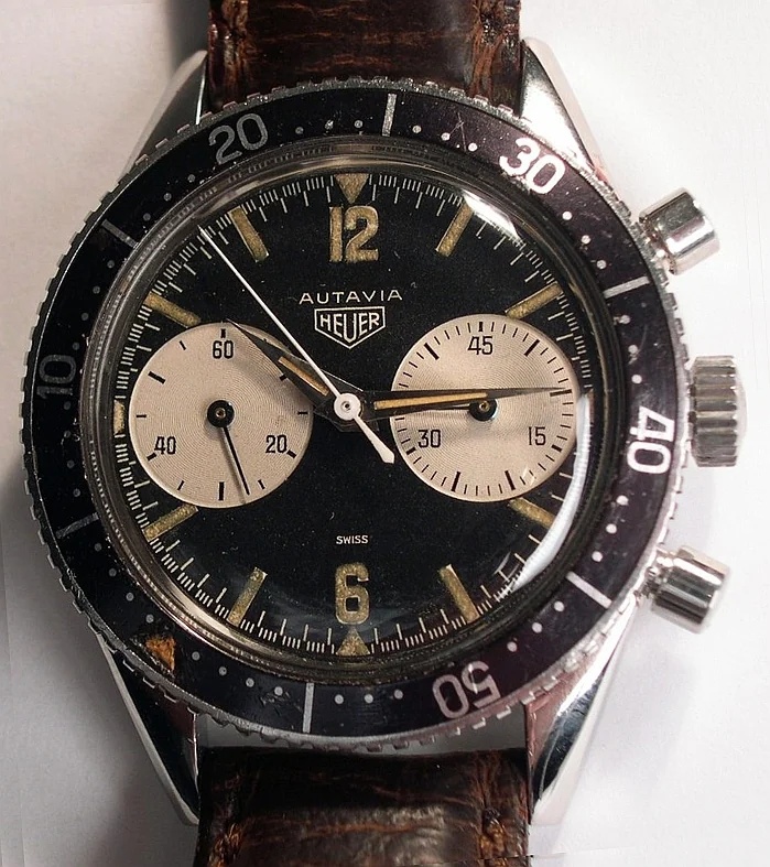 A 1960s Heuer Autavia chronograph with a black dial, two light sub-dials and a rotating black bezel