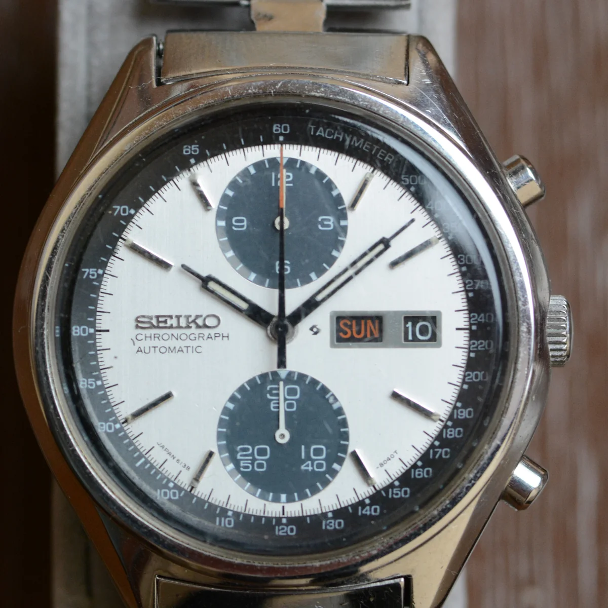 A 1977 Seiko 6138-8020 automatic chronograph with a white panda dial, two dark blue-grey sub-dials at 12 and 6, a black tachymeter ring and a day-date window