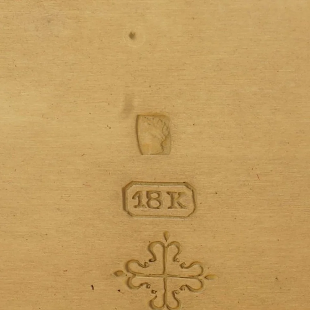 Swiss Helvetia head hallmark above an 18K stamp and the Calatrava cross inside a gold pocket watch case