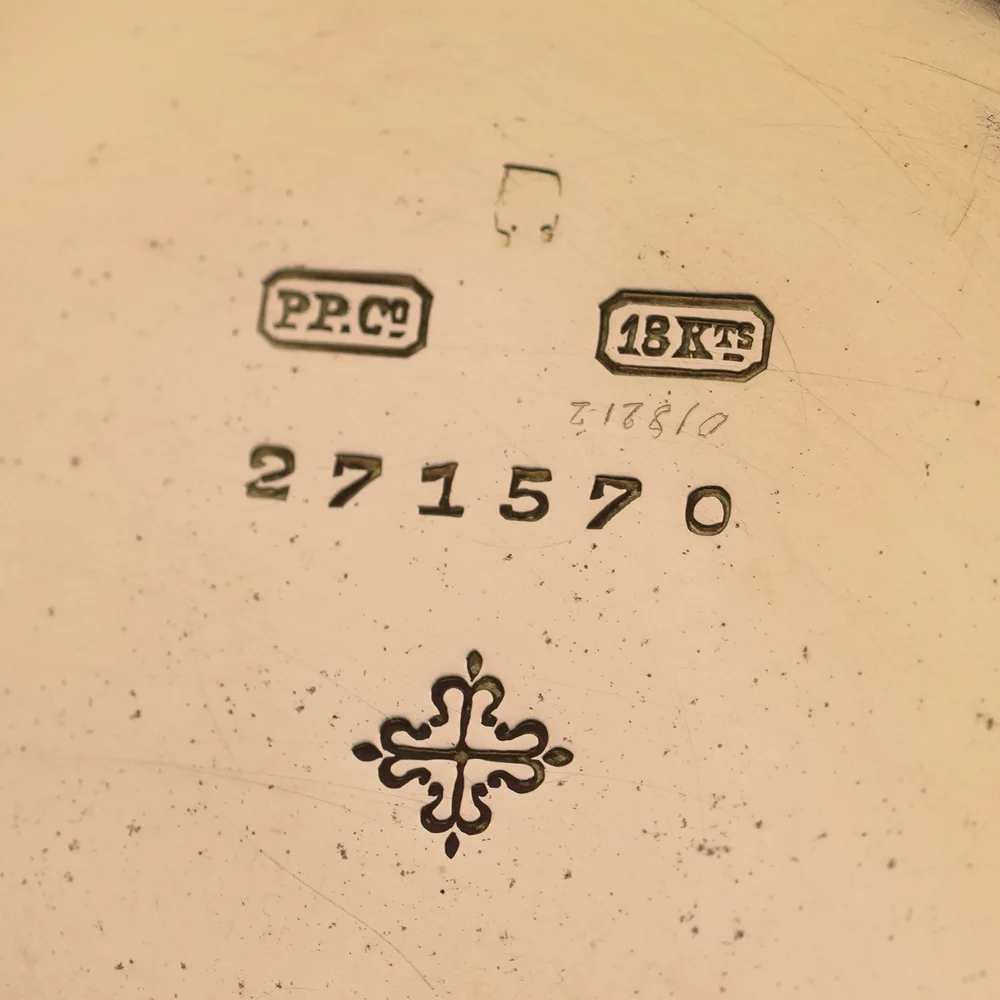 Inside the case back of a Swiss 18ct gold pocket watch: 18Kts stamp, case number and Calatrava cross, with no British hallmarks