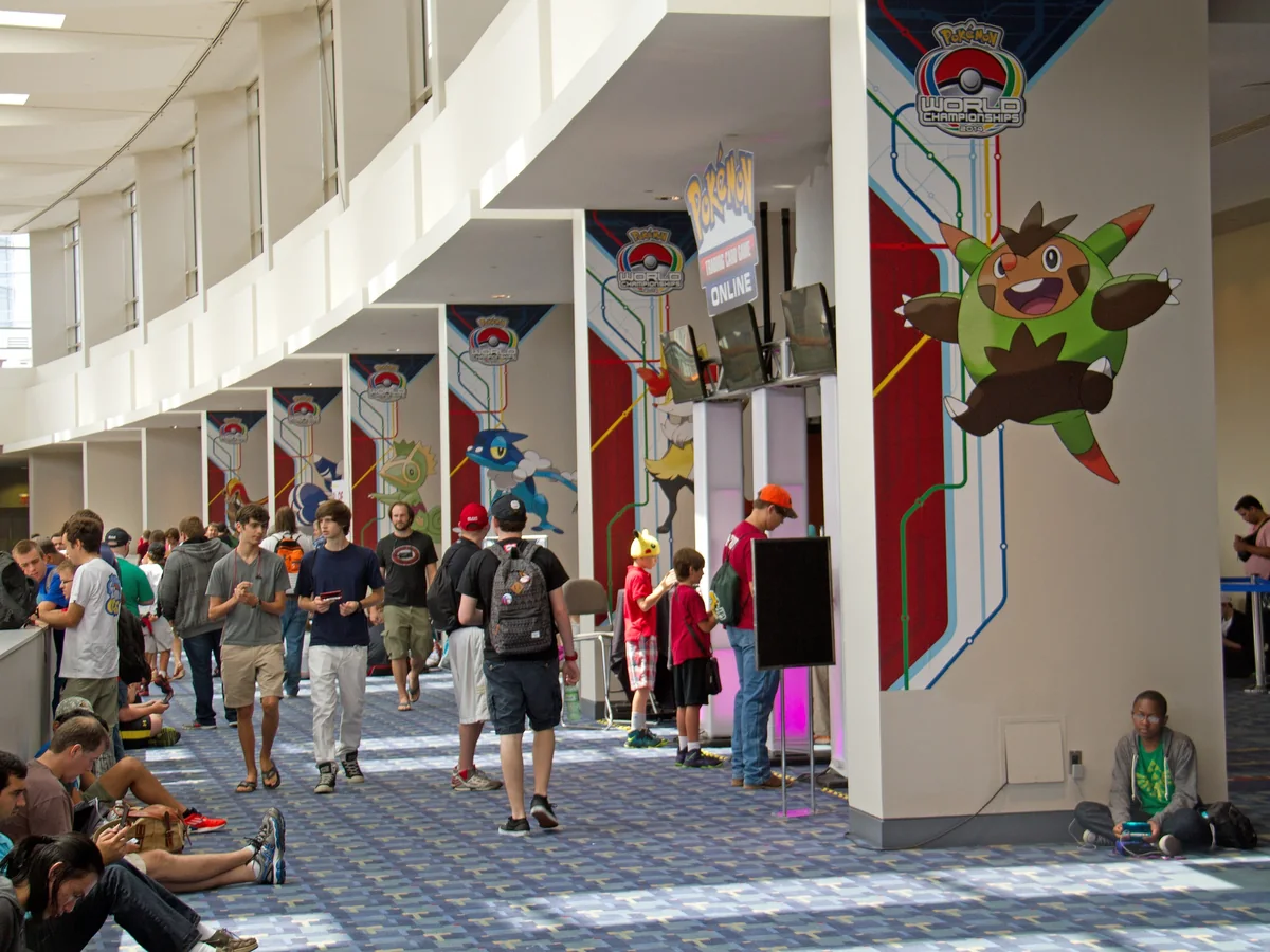 The hall of the 2014 Pokémon World Championships in Washington DC, with Pokémon banners on the pillars and players waiting between rounds