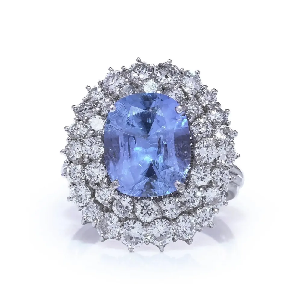 18KT white gold cluster ring with a 5.91 ct cushion-cut Ceylon sapphire framed by two rows of brilliant-cut diamonds