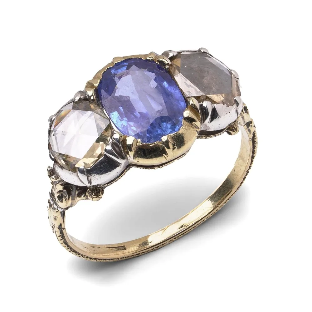 Victorian 18KT gold ring with an oval Ceylon sapphire between two rose cut diamonds in silver-topped settings