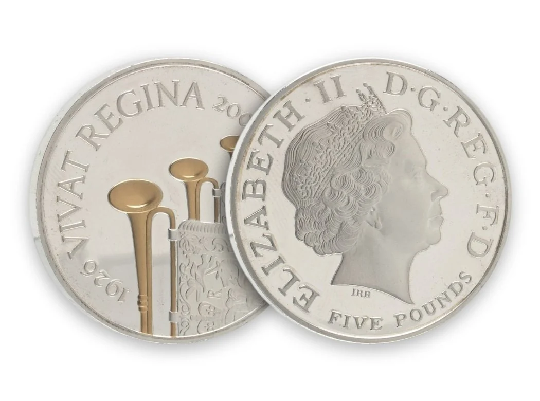 Both sides of a 2006 silver piedfort proof five pound coin with gold-plated trumpets on the reverse