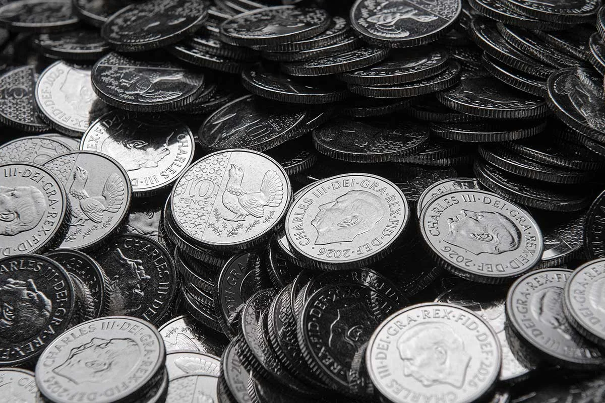 A heap of new King Charles III 10p coins, some showing the King's portrait and some the capercaillie design