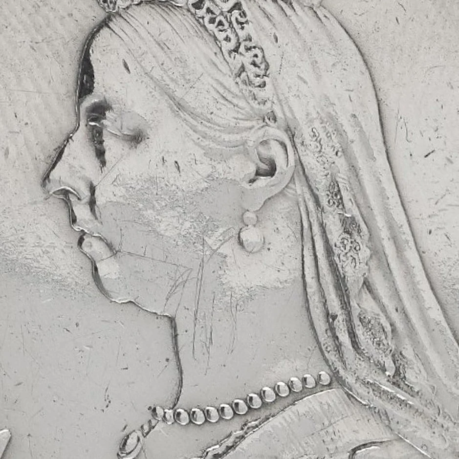 Close-up of Queen Victoria's portrait on an 1887 silver crown, showing light wear on the cheek, veil and hair