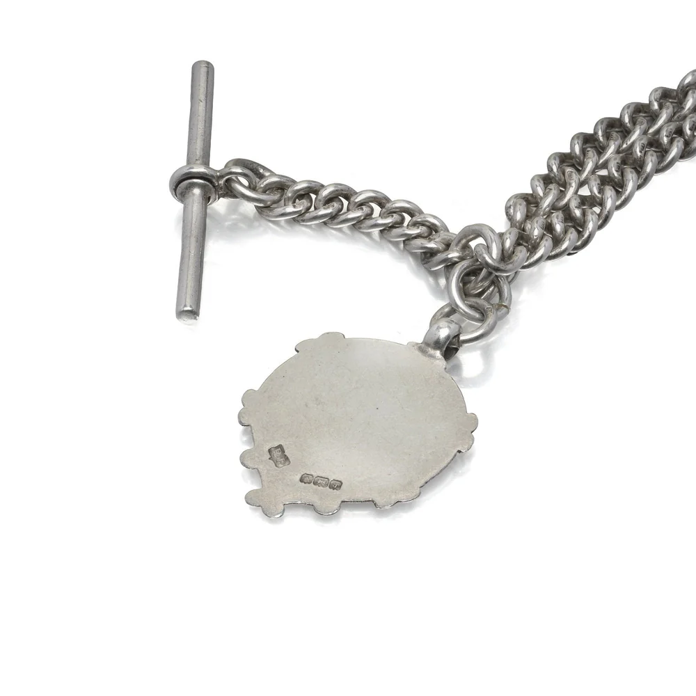 The T-bar and gold-faced shield fob of an antique silver Albert chain, Birmingham 1926
