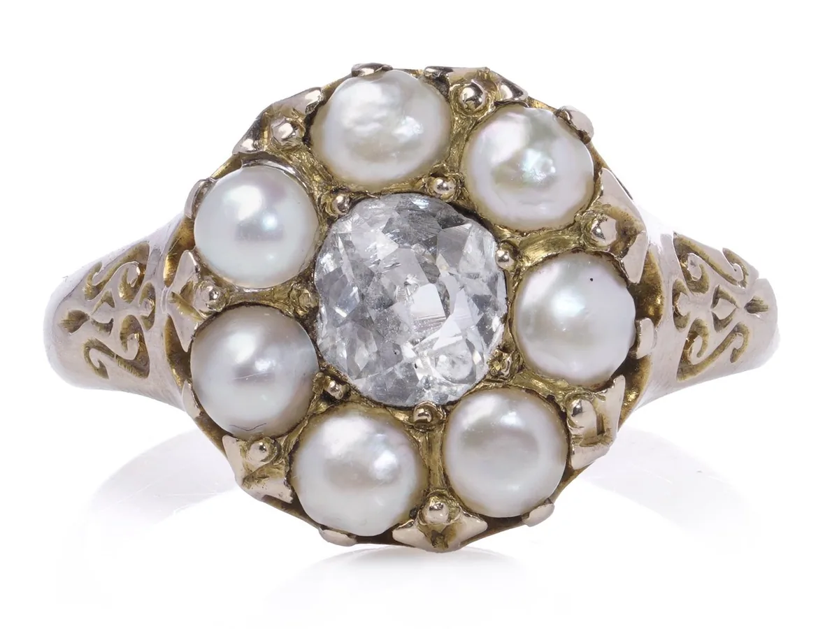 Antique yellow gold cluster ring with an old mine cut diamond centre and a ring of natural pearls, seen front on