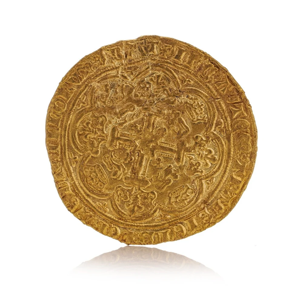 The reverse of a hammered gold noble of Edward III, with an ornate cross and lions inside a border of arches