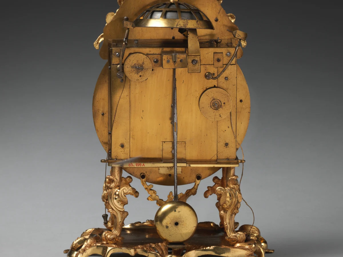 The back of an 18th-century London table clock with its brass movement and short pendulum exposed