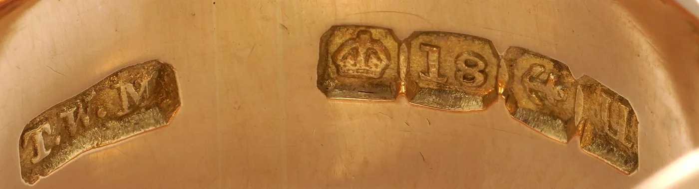 Birmingham hallmarks for 1919 inside an 18KT gold buckle ring by Thomas William Martin: maker's mark, crown and 18, anchor and date letter