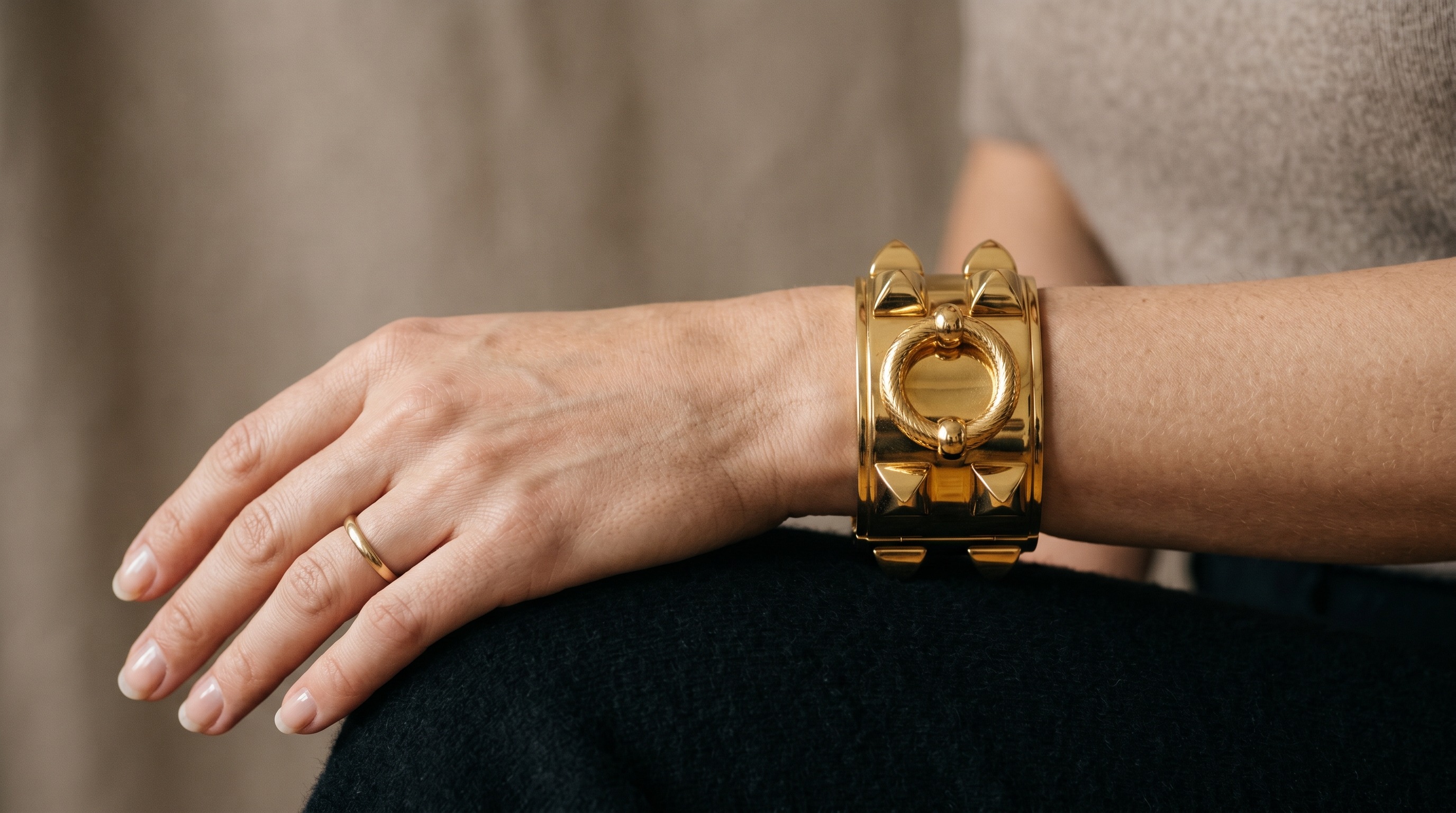 Hermès Collier de Chien-style studded gold cuff on the wrist