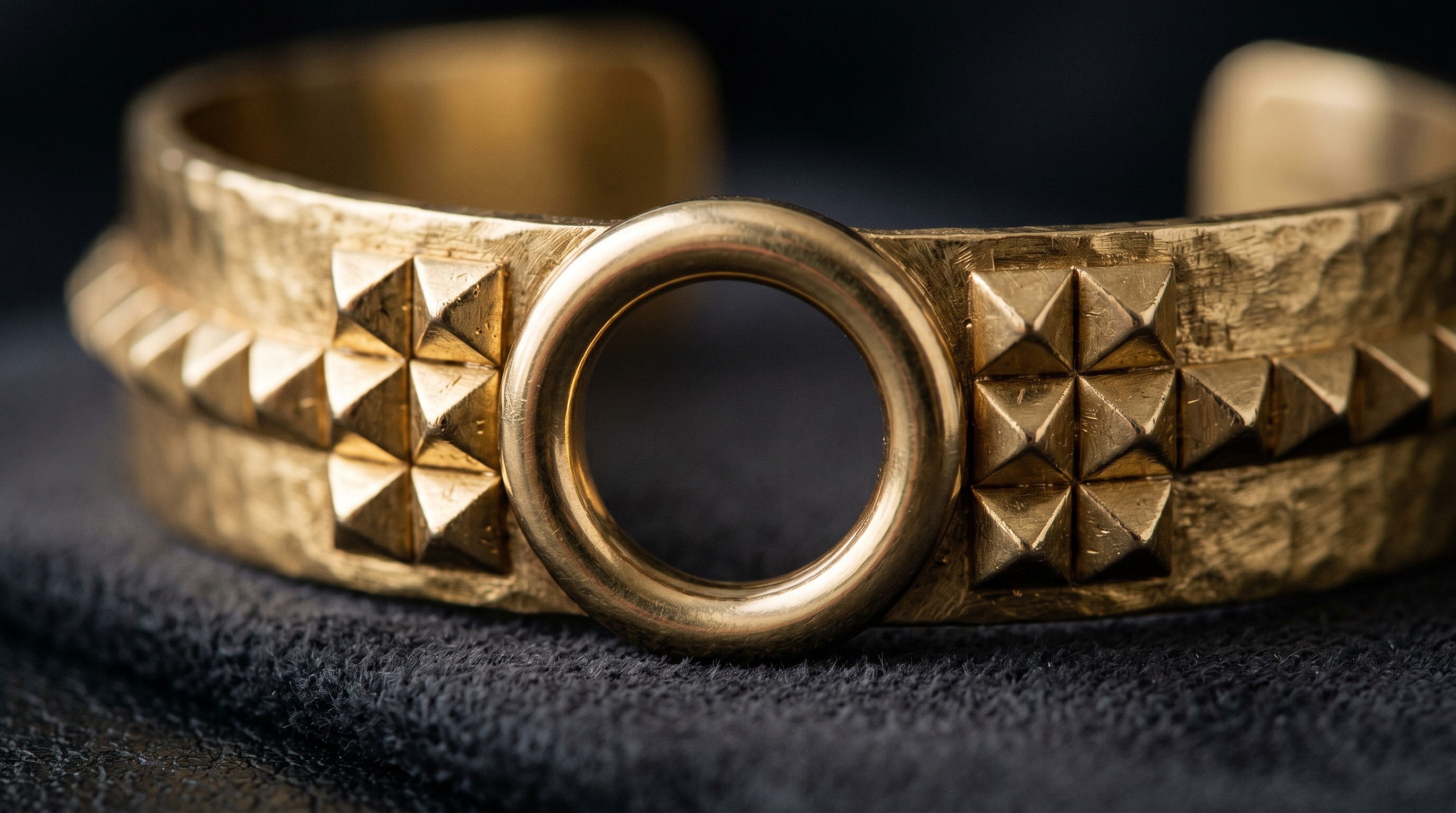 Close-up of pyramid studs and central ring on a Hermès Collier de Chien cuff
