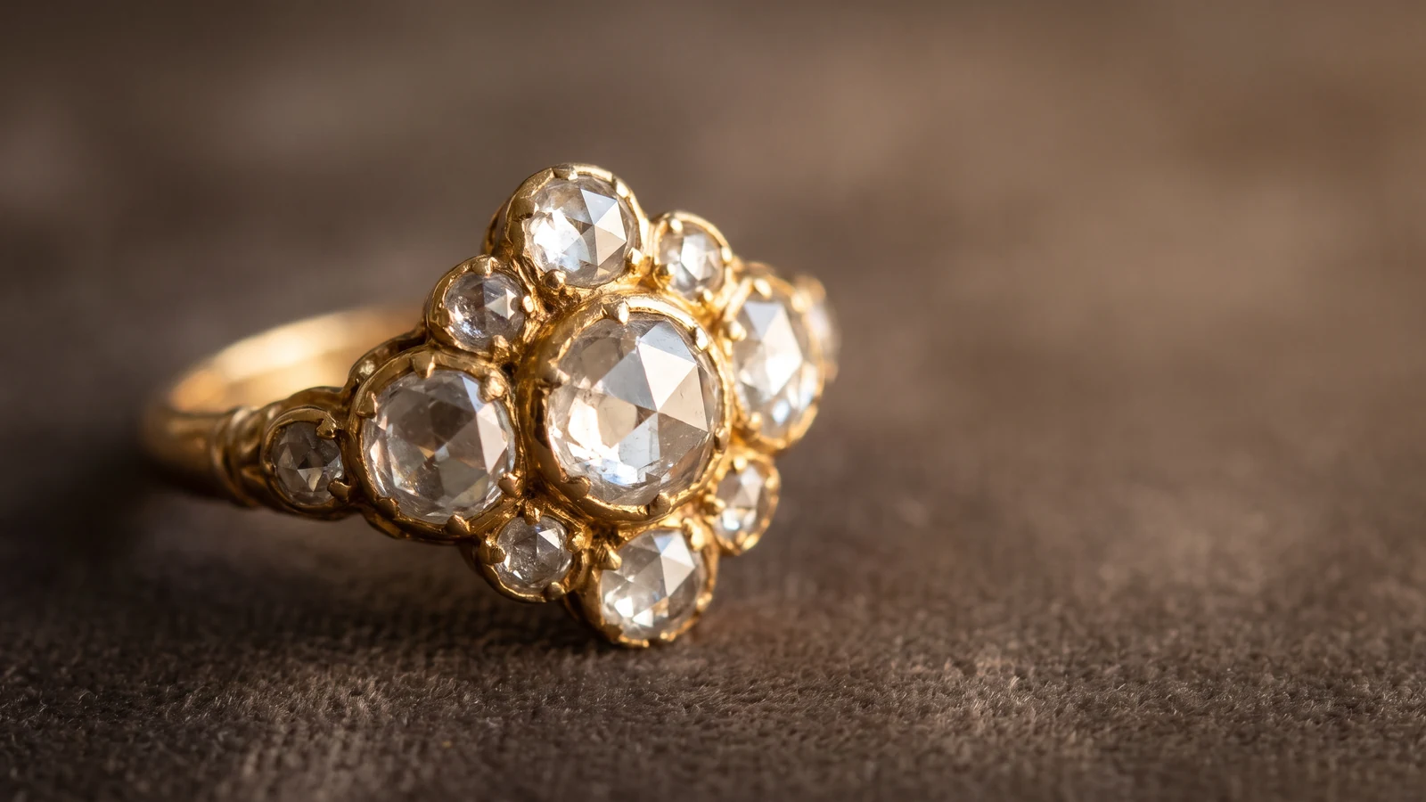 A rose-cut diamond cluster ring with flat-backed stones on a dark background