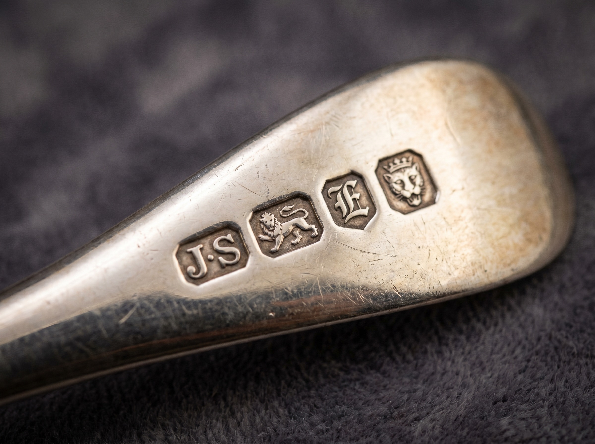 Extreme macro of London silver hallmarks on 18th century sterling silver — maker's initials, leopard's head, lion passant, date letter