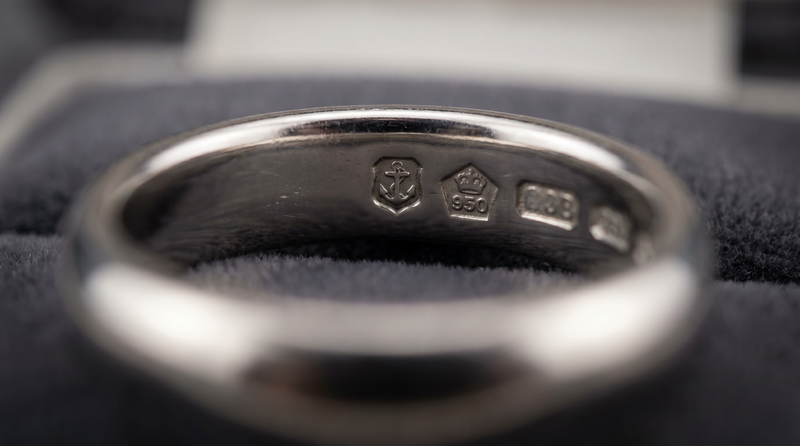 Full row of UK platinum hallmark punches inside a ring band