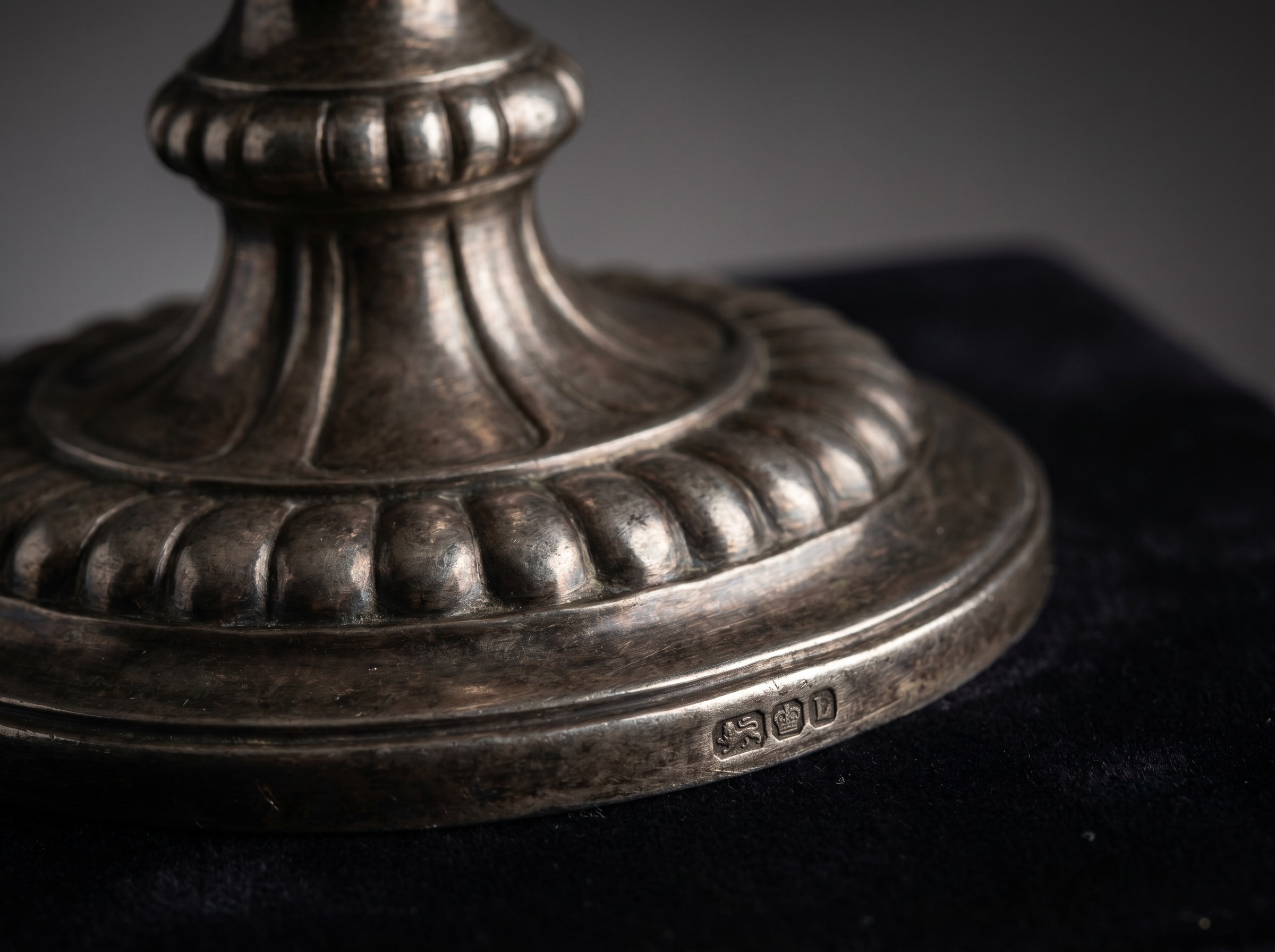 Heavy moulded gadrooned base and stem of an antique English sterling silver candelabrum