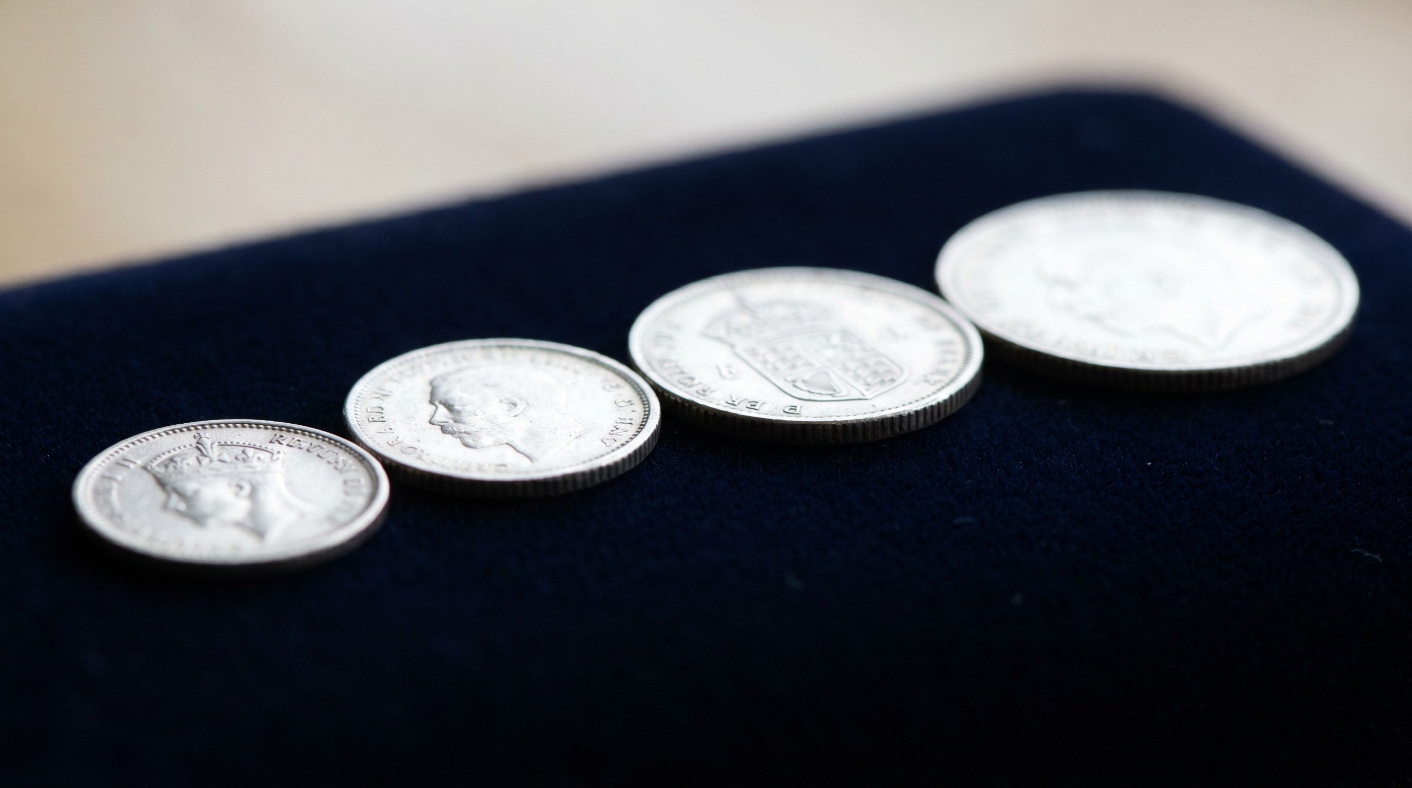 Four tiny graduated British silver Maundy coins in a row