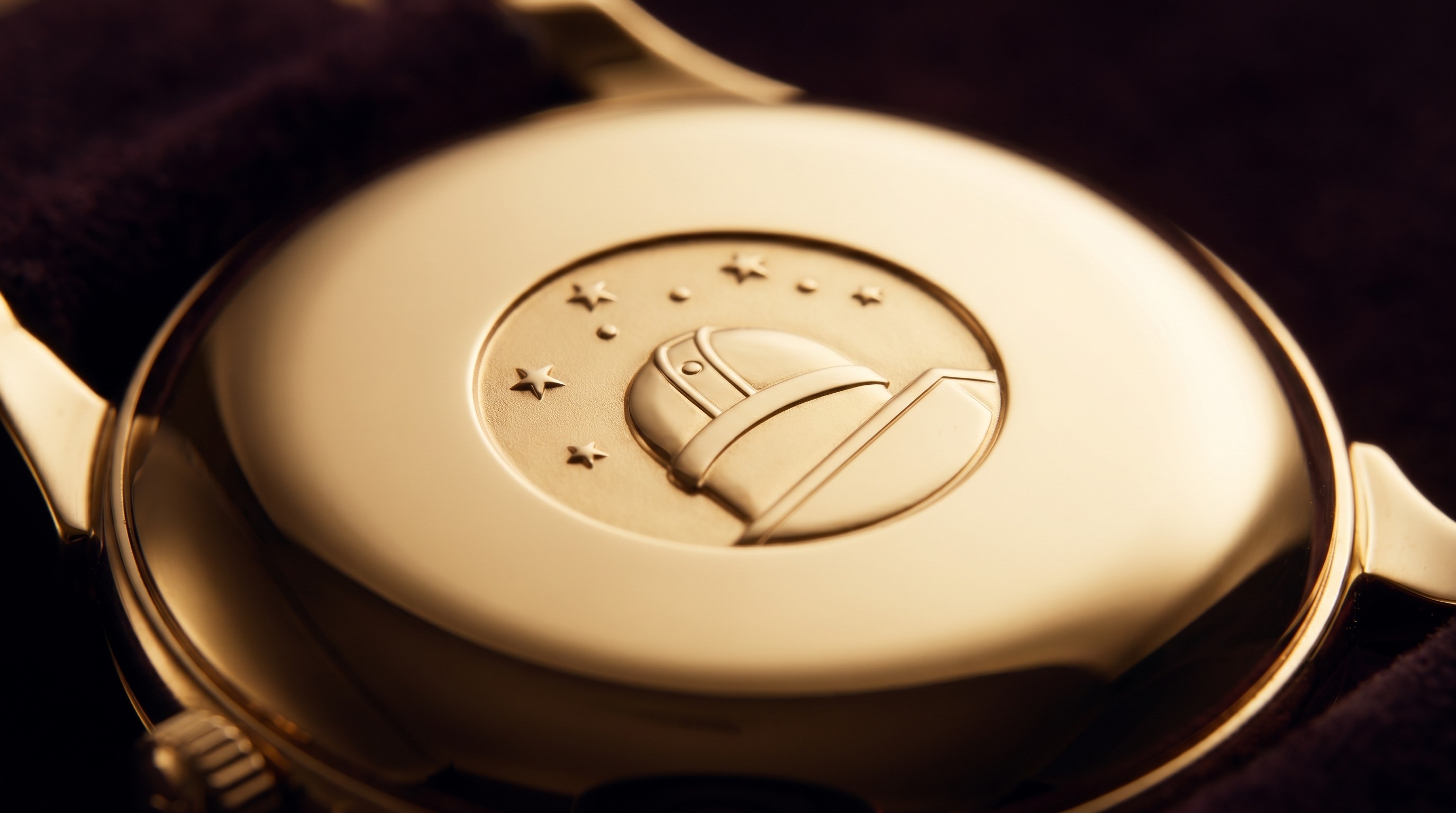 Domed yellow gold watch case-back with embossed observatory and star medallion