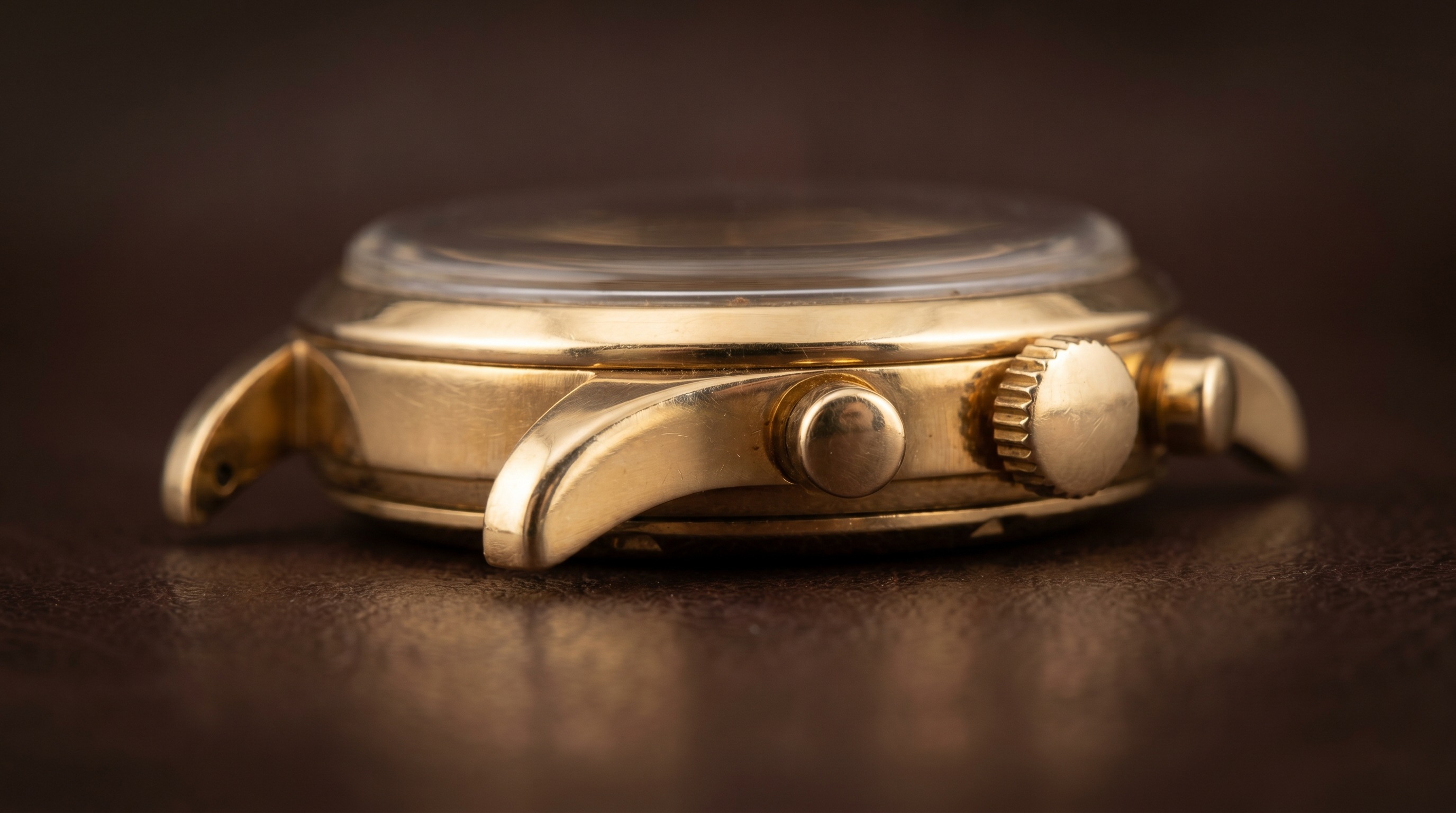 Macro of a vintage gold chronograph case, pushers and crown